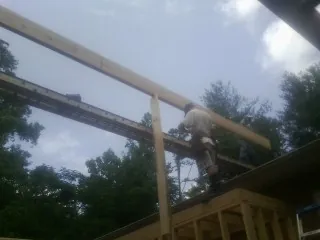 Carpenter setting a ridge beam over a new addition frame — Ice Dam Removal by Roofing Brothers in Oshkosh