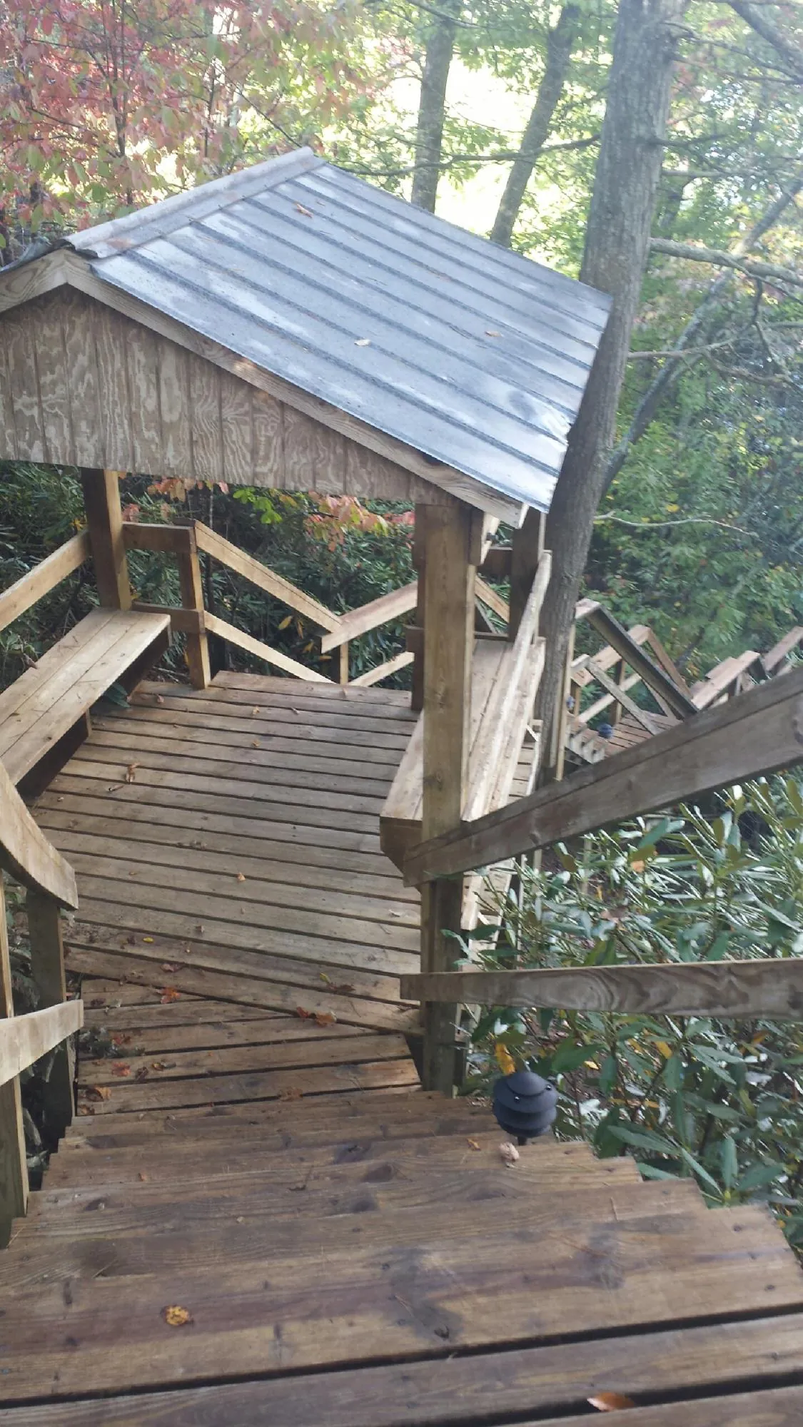 Metal roofed shelter over wooden steps on a wooded walkway — Skylight Repair & Installation work by our crew in Oshkosh