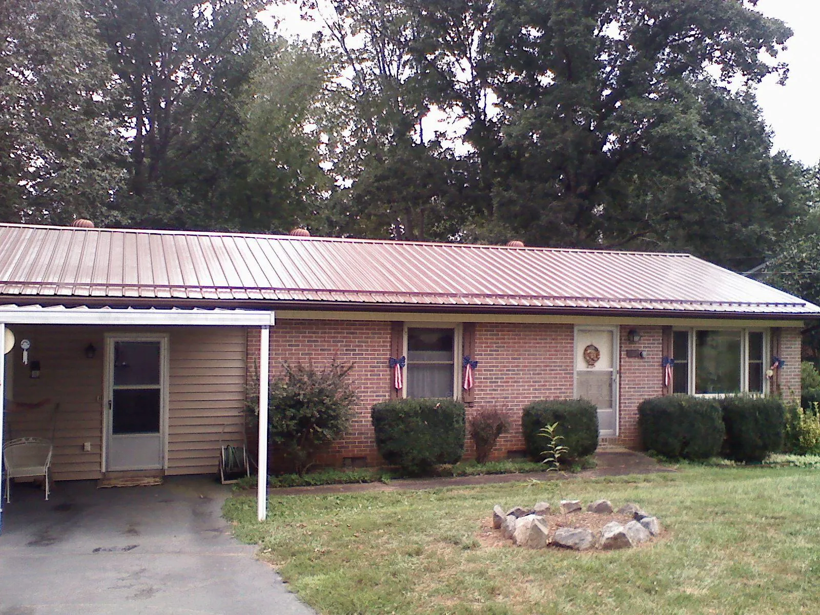 Bronze metal roof and carport on a brick ranch home — Roof Repair work by our crew in Oshkosh